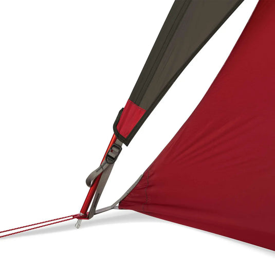 Nahaufnahme einer rot-grauen MSR® FreeLite™ 1 „V2“ Ultraleichtes 1-Personen-Backpacking-Zelt-Ecke mit Abspannleine und Hering.