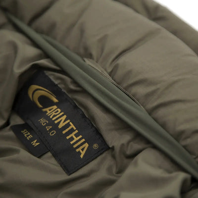 Nahaufnahme eines Markenetiketts der Carinthia® HIG 4.0 Jacke auf olivgrünem Stoff, Outdoor-Kleidung oder Ausrüstung.