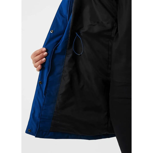 Person, die das Innenfutter und die Taschendetails eines Frida-Winterparkas für Damen von Helly Hansen® mit blauer Innenseite präsentiert.