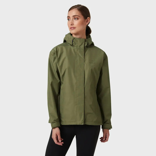 Frau trägt eine grüne, wasserdichte Helly Hansen® Women's Seven J Rain Jacket mit dem Markenlogo auf der Brust.