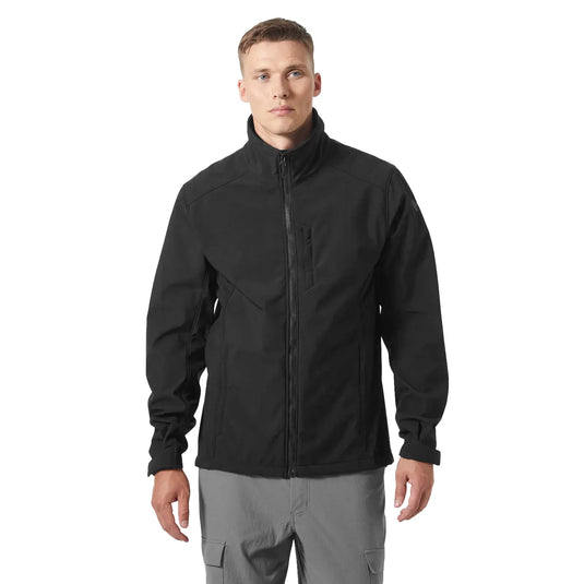 Mann, der eine schwarze Paramount Softshell-Jacke für Herren von Helly Hansen® und eine graue Hose trägt, steht vor einem weißen Hintergrund.