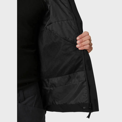 Nahaufnahme der Seite einer Person, die eine schwarze Banff Shell-Jacke für Herren von Helly Hansen® mit Reißverschlusstaschendetail trägt.