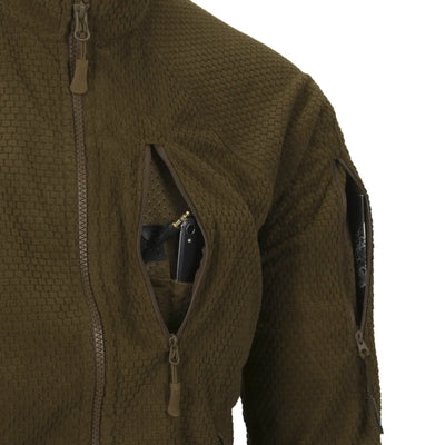 Nahaufnahme einer Helikon-Tex® Alpha Tactical Jacket – Grid Fleece mit einer verdeckten Tasche, die eine Pistole enthält.