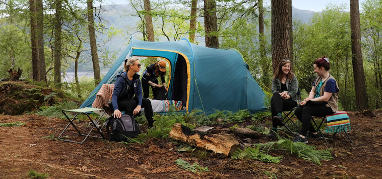Eine Gruppe von Freunden genießt einen Campingausflug in einer Waldumgebung.