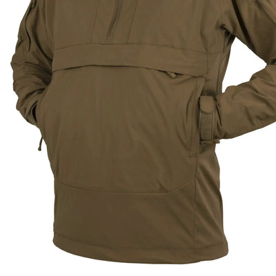 Eine Nahaufnahme einer Person, die eine khakifarbene Helikon-Tex® Mistral Anorak Jacket®-Jacke im Militärstil trägt.