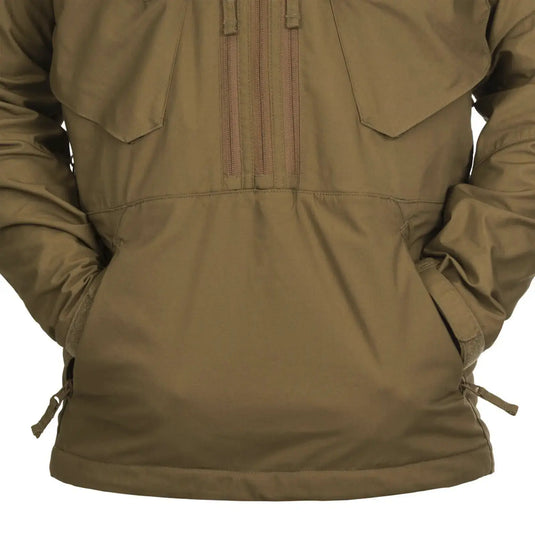 Eine Nahaufnahme einer olivgrünen Helikon-Tex® Pilgrim Anorak Jacke mit Details wie Nähten, Taschen und Kordelzügen.