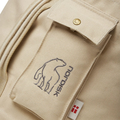 Nahaufnahme einer beigen Stofftasche mit gesticktem Pferdelogo und einem kleinen, haltbaren Flaggenetikett am Nordisk® Kongsberg 40 Duffle Rucksack.