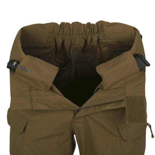 Nahaufnahme einer olivgrünen Helikon-Tex® Urban Tactical Hose mit elastischem Bund und mehreren Taschen aus Polycotton Ripstop, isoliert auf weißem Hintergrund.