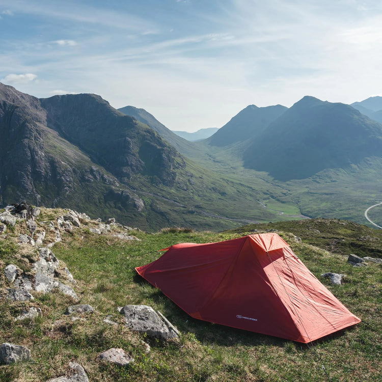 Ein Zelt auf einem Berg mit Blick auf ein malerisches Tal.