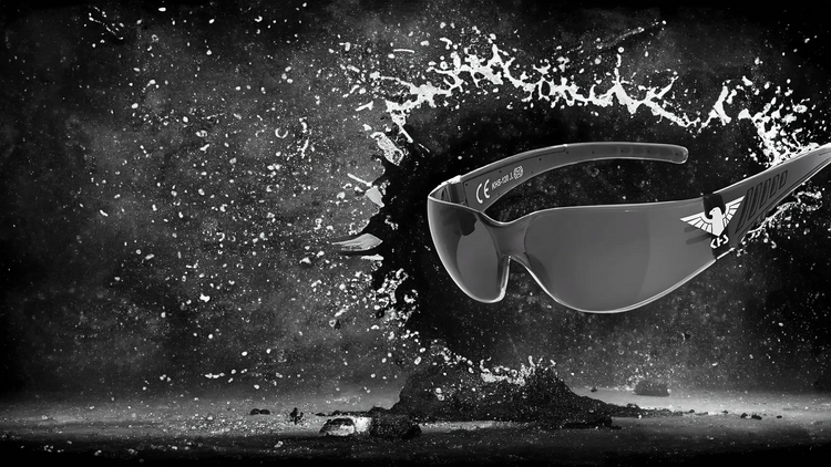 Dramatisch schwebende Sonnenbrillen mit spritzenden Wassertropfen in einer schwarz-weißen Umgebung.