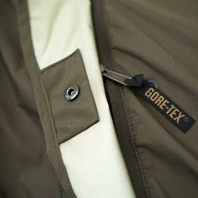Nahaufnahme einer Carinthia® OBSERVER PLUS Gore-Tex-Jacke mit Reißverschluss und Knopfverschluss.