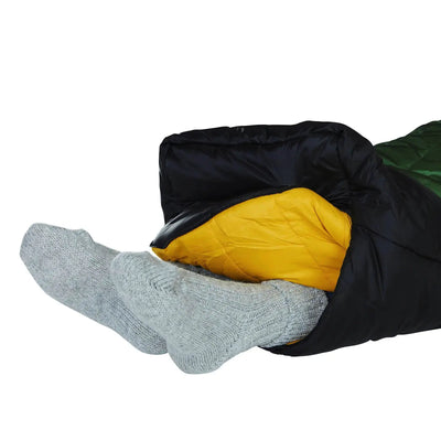 Person in einem Nordisk® Gormsson -10° Mumien-Winterschlafsack mit grauen Socken, aus dem die Füße herausragen.