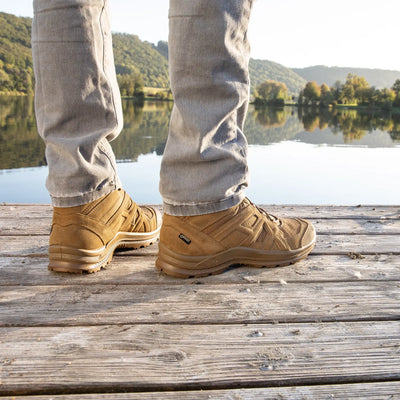 Person steht auf einem Holzsteg an einem See und trägt beige HAIX® BLACK EAGLE® ATHLETIC 2.0 V GTX-Schuhe.