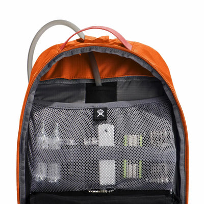 Ein offener orangefarbener Rucksack mit einer sichtbaren Netztasche, in der sich ein Hydro Flask® 14 L Down Shift™ Trinkrucksack und verschiedene Gegenstände befinden.