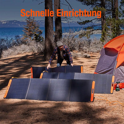 Person, die ein Jackery SolarSaga 200 Solarpanel in der Nähe eines Campingplatzes am Seeufer aufstellt.