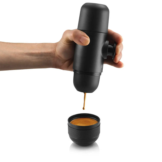 Espresso aus einem WACACO® Minipresso, einem tragbaren Espressokocher von WACACO®, in eine Tasse gießen.