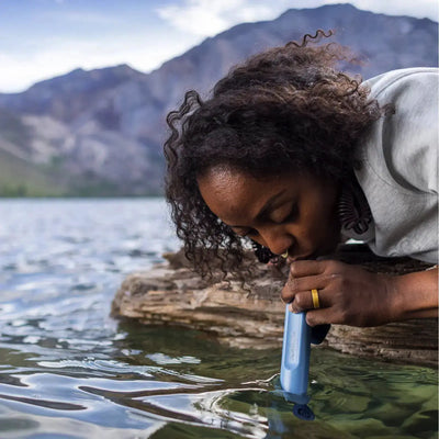 Eine Person, die einen Strohhalm der LifeStraw® Peak-Serie verwendet, um aus einem Bergsee zu trinken.