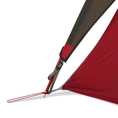 Nahaufnahme einer roten ultraleichten MSR® FreeLite™ 1 „V3“ 1-Personen-Backpacking-Zelt-Ecke mit Hering und Spanngurt.