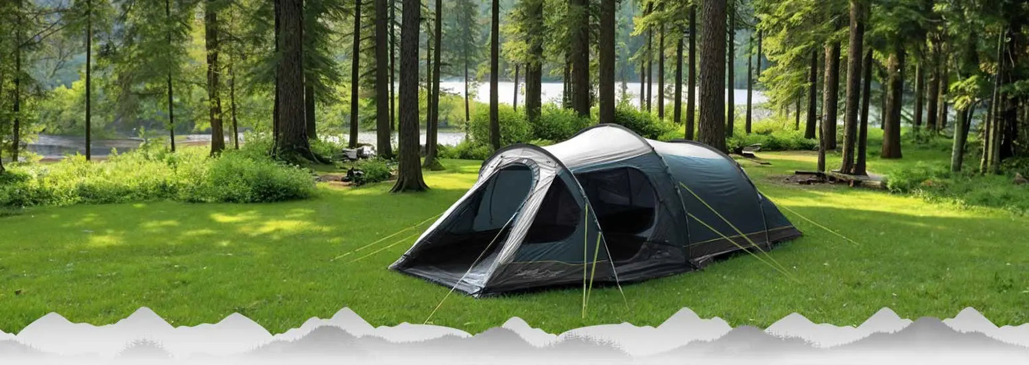 Campingzelt auf einer grasbewachsenen Lichtung in der Nähe eines Waldes aufgestellt.