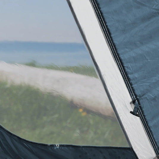 Blick auf einen Strand durch eine teilweise geöffnete Zeltklappe des Outwell® Cloud 4.