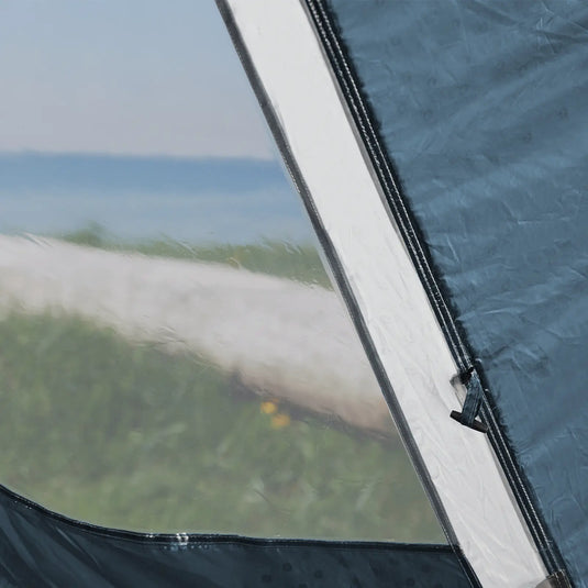 Nahaufnahme eines Outwell® Earth 2-Reißverschlusses mit verschwommenem Blick auf einen Strand im Hintergrund.