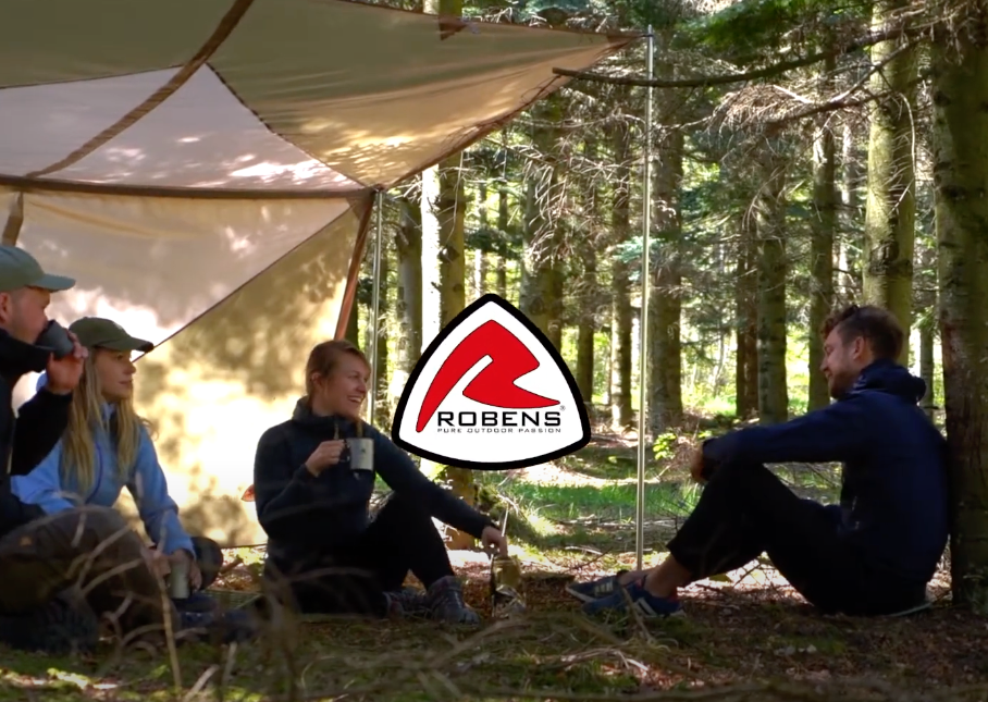 Eine Gruppe von Freunden unterhält sich unter einem Blätterdach im Wald, wobei das Robens-Logo sichtbar ist.