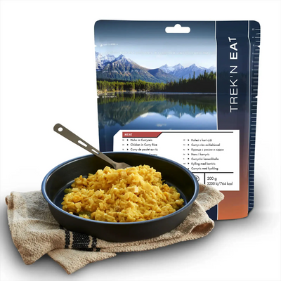 Satz mit ersetztem Produkt:

Packung mit gefriergetrocknetem Hähnchen-Curry-Reis-Gericht von AlpineAire Foods neben einer gekochten Portion in einer schwarzen Pfanne, mit einer malerischen Berglandschaft im Hintergrund.