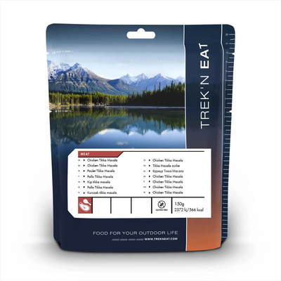 Verpackte gefriergetrocknete Trek'n Eat Chicken Tikka Masala-Mahlzeit für Outdoor-Aktivitäten mit Nährwertangaben und malerischer Berglandschaft auf der Verpackung.