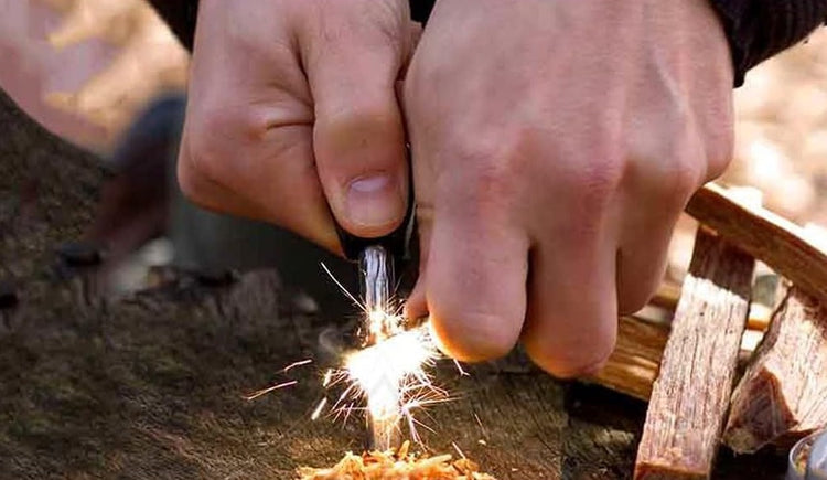 Hände benutzen Feuerstahl zum Entfachen eines Funkens, Survival-Technik.